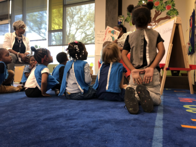 Children listening to a teacher read a story